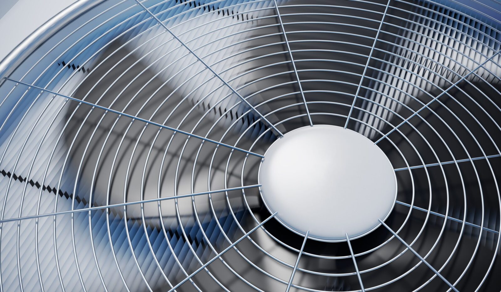 Close-up of metal fan with protective grille.